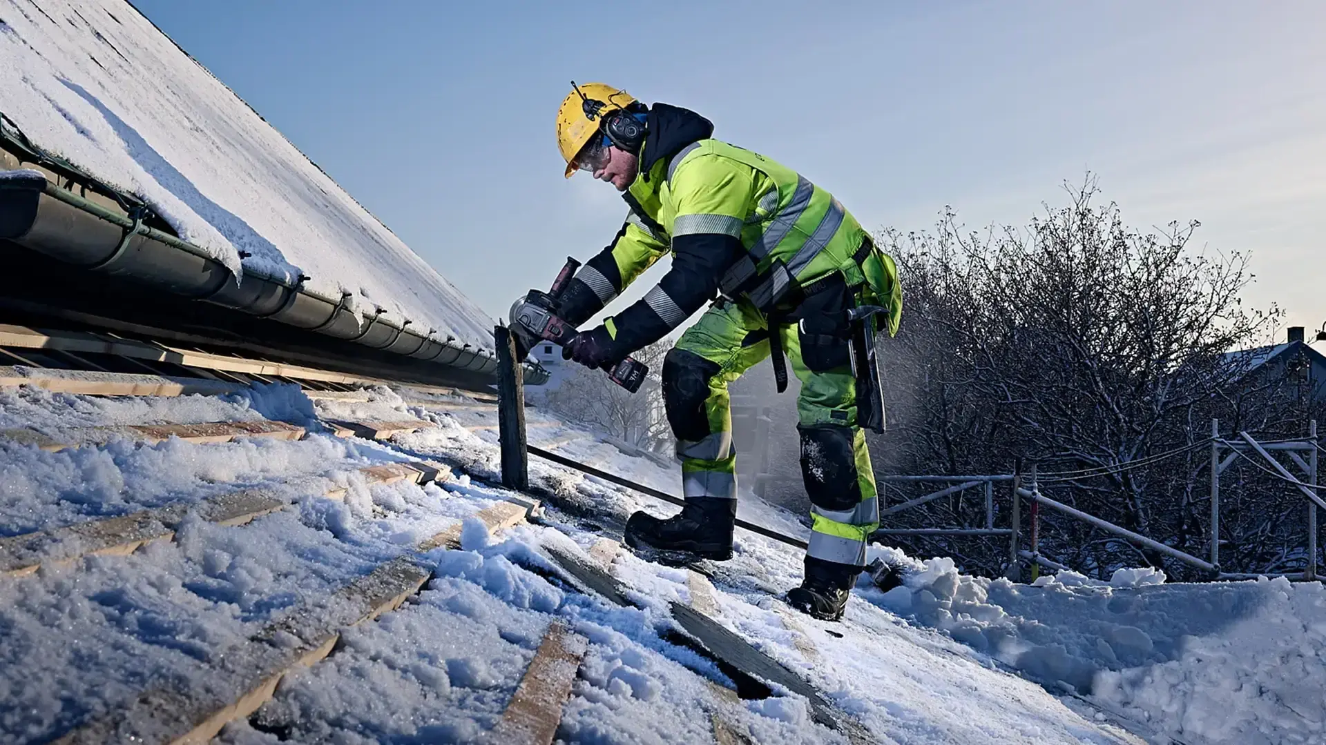 Foto av en person i arbeidsdress som jobber på tak